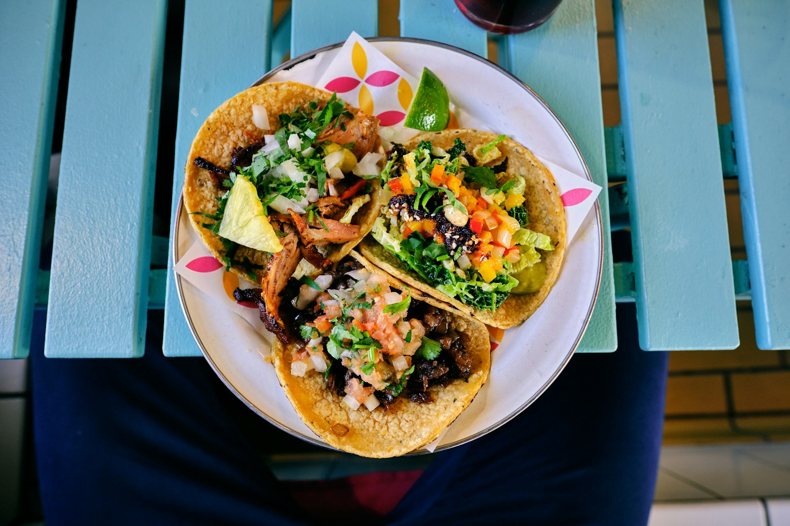 Three-taco plate with lime on the patio table